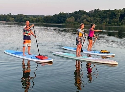 three people on stand up paddle boards